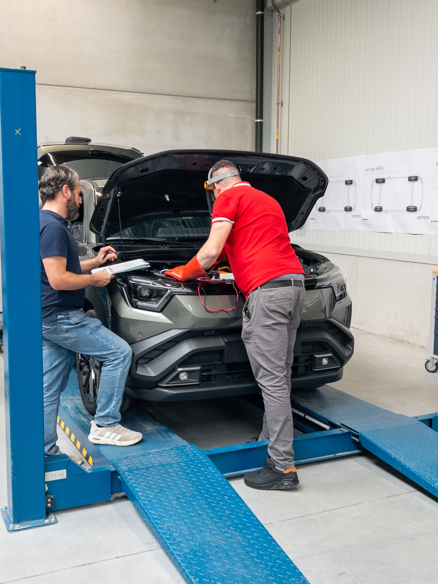 Two technicians working together on an open vehicle in the IAS workshop